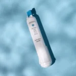 Top-down artistic view of a single Everydrop EDR3RXD1 filter on a blue water background, highlighting the blue nozzle that replaces Puriclean II and Kenmore 9030 models.